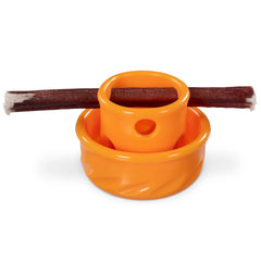 Orange mini dog toy with treat inserted in the holes for challenging interactive play.