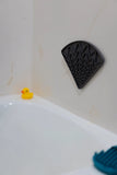 Triangle dog lick mat in the bath. Suction cups to stick to the wall. 