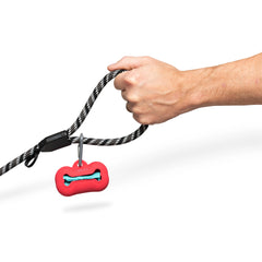 Watermelon dog poop bag holder hanging from a grey rope leash by its grey carabiner 