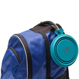 Blue Collapsible silicone travel bowl with carabiner clipped on a backpack